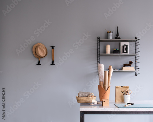 Details eines Zimmers: Arbeitsplatz, Schreibtisch, Wandregal, Wandhaken, Papierrollen photo