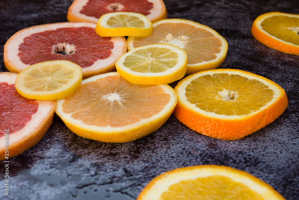 Sliced citrus fruits on black ground Sliced citrus fruits on black ground