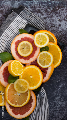 Colorful assortment of citrus fruits. Dark background © Milkica