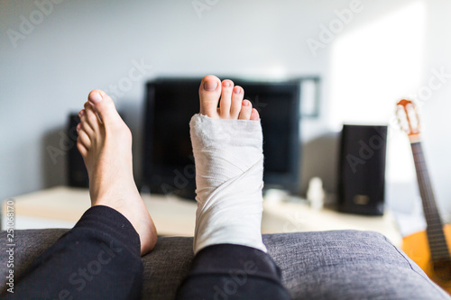 man in front of the TV with a broken leg photo