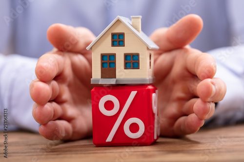 Foto Person Protecting House Model Over Cube With Percentage Symbol