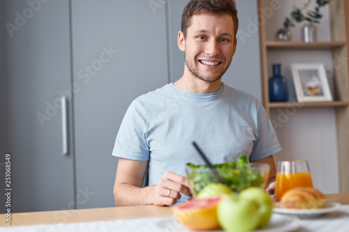 Smiling guy with delicious and healthy breakfast  