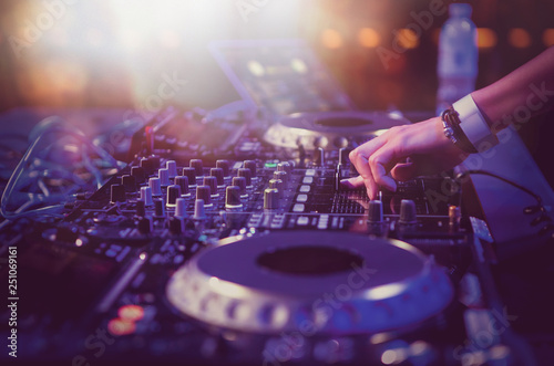 Fotografie Female dj plays live music set on stage in night club