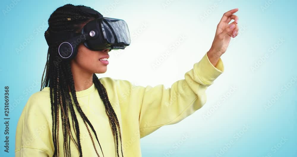 New technology african lady with a VR typing with finger virtual to select a program to use in a studio with a blue background wall New technology african lady with a VR typing with finger virtual to select a program to use in a studio with a blue background wall