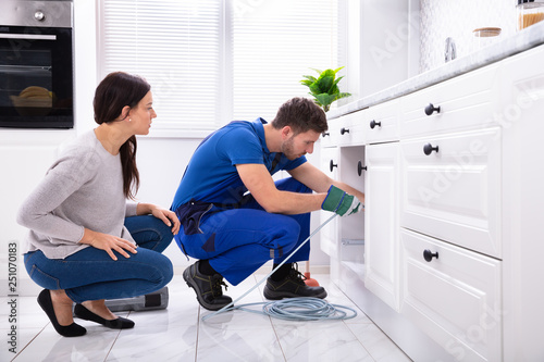 Male Plumber Cleaning Clogged Sink Pipe With Drained Cable
