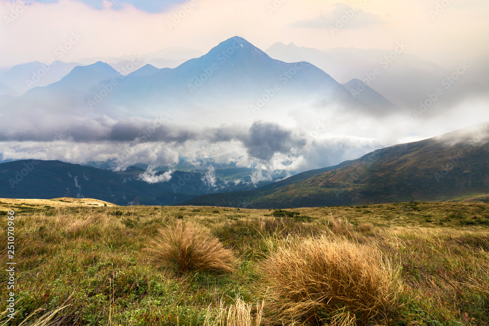 Fototapeta premium Green mountains panoramic view on blue sky with white clouds copy space background on bright sunny day. Tourism and traveling concept.