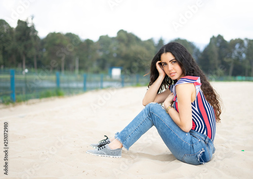Young girl sitting on the beach