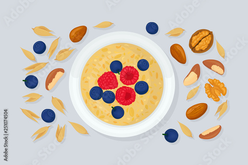 Porridge oats in bowl with bananas, berries, strawberry, nuts and cereals isolated on white background. Healthy breakfast