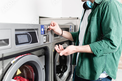 Young man doing his weekly washing in a laundromat.