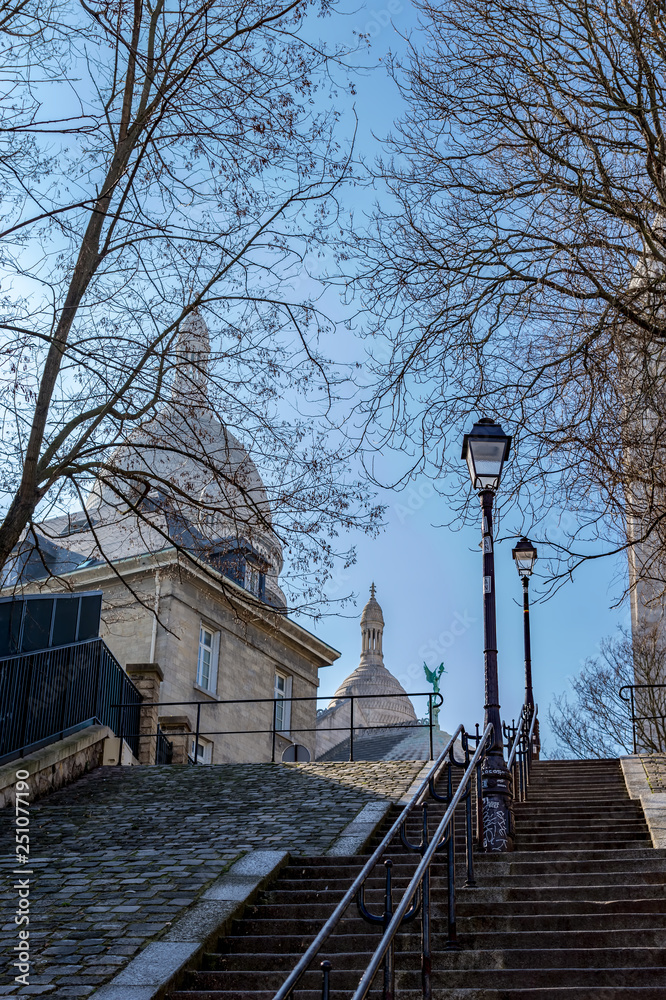 Typical Montmartre staircase with old street lamp and sacre coeur in background in winter. Paris, France Typical Montmartre staircase with old street lamp and sacre coeur in background in winter. Paris, France