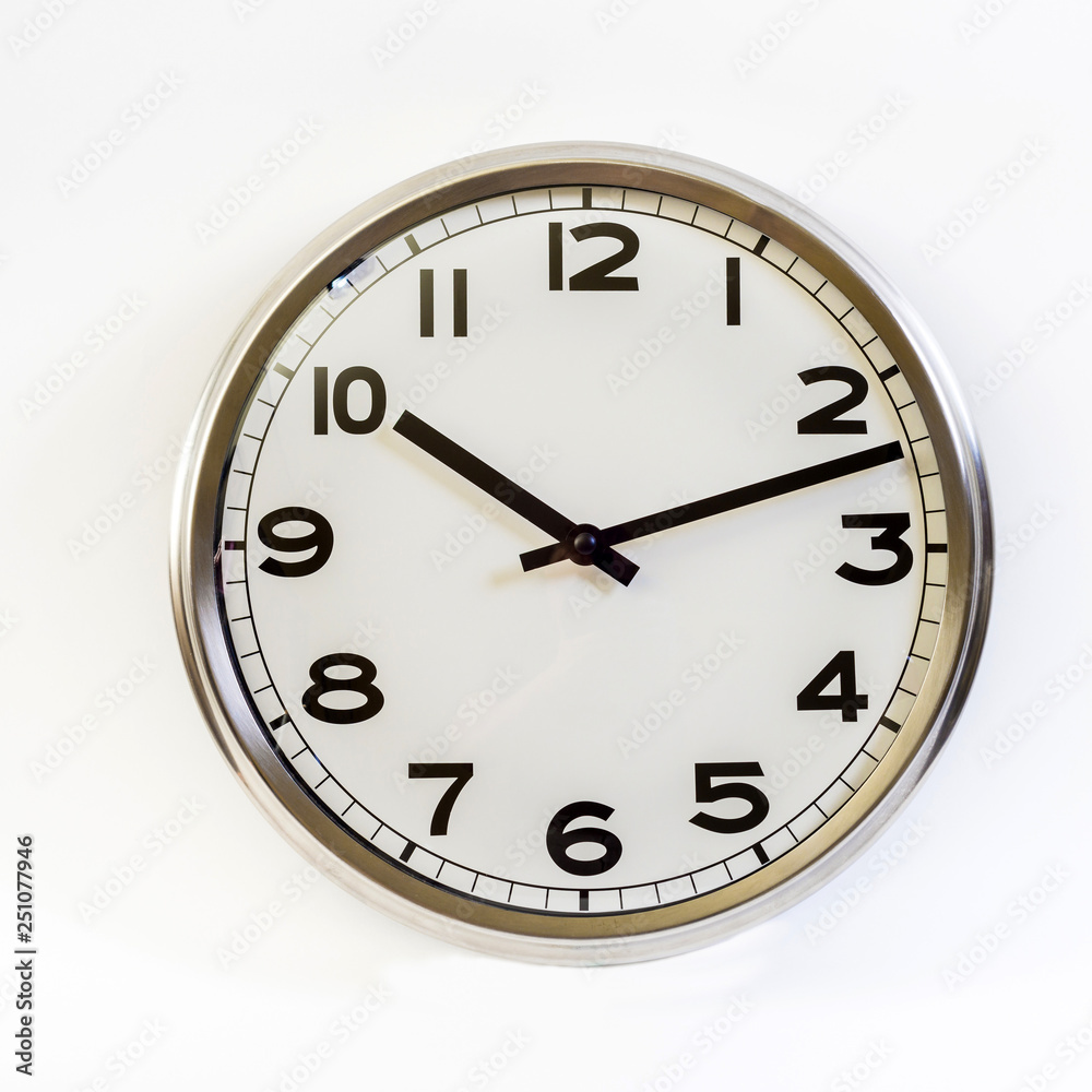 Steel retro clock on white isolated background. The arrows point to the beginning of the eleventh. Steel retro clock on white isolated background. The arrows point to the beginning of the eleventh.