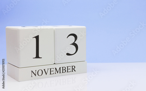 November 13st. Day 13 of month, daily calendar on white table with reflection, with light blue background. Autumn time, empty space for text