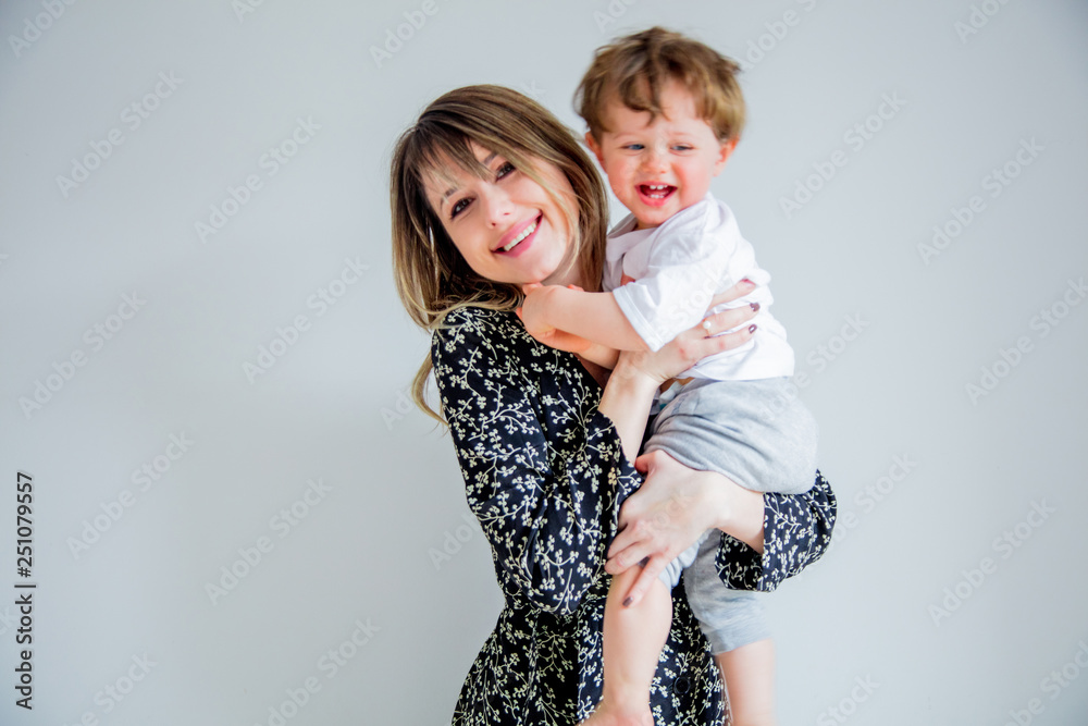 Mother and son on a white wall background at home Mother and son on a white wall background at home