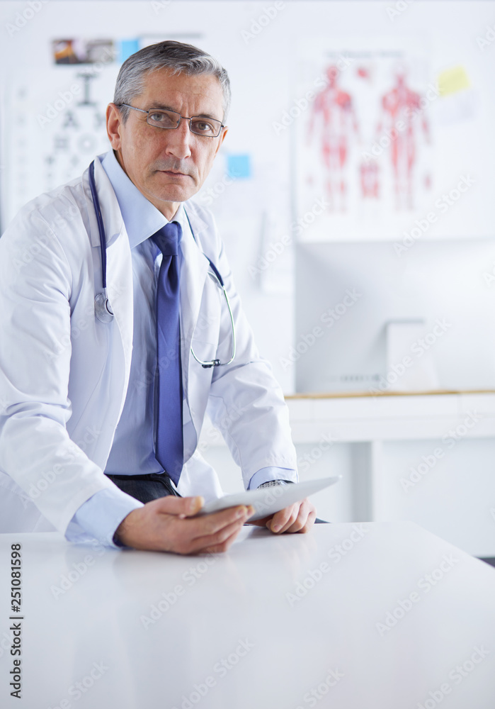 Portrait of a smiling doctor in his bright office