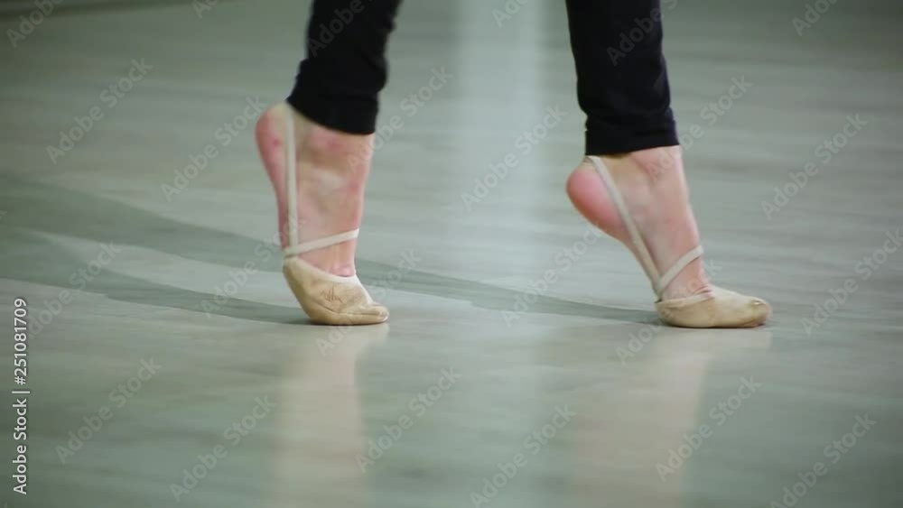 Close-up feet of ballerina in pointe performs dance ballet elements and different exercises in sport gym for rhythmic gymnastics Close-up feet of ballerina in pointe performs dance ballet elements and different exercises in sport gym for rhythmic gymnastics
