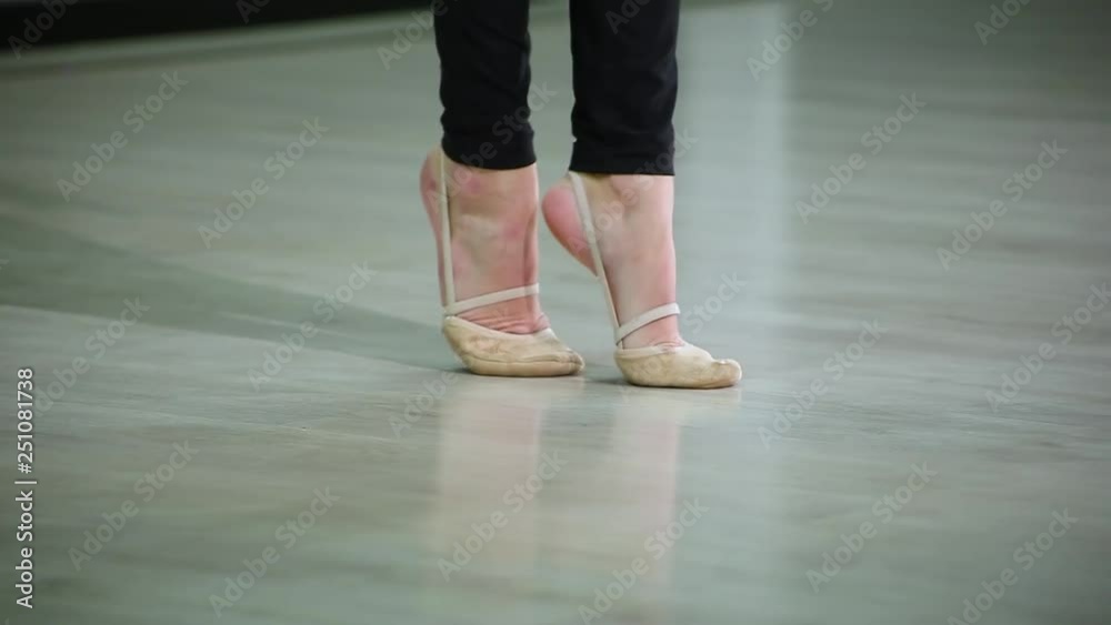 Close-up feet of ballerina in pointe performs dance ballet elements and different exercises in sport gym for rhythmic gymnastics Close-up feet of ballerina in pointe performs dance ballet elements and different exercises in sport gym for rhythmic gymnastics