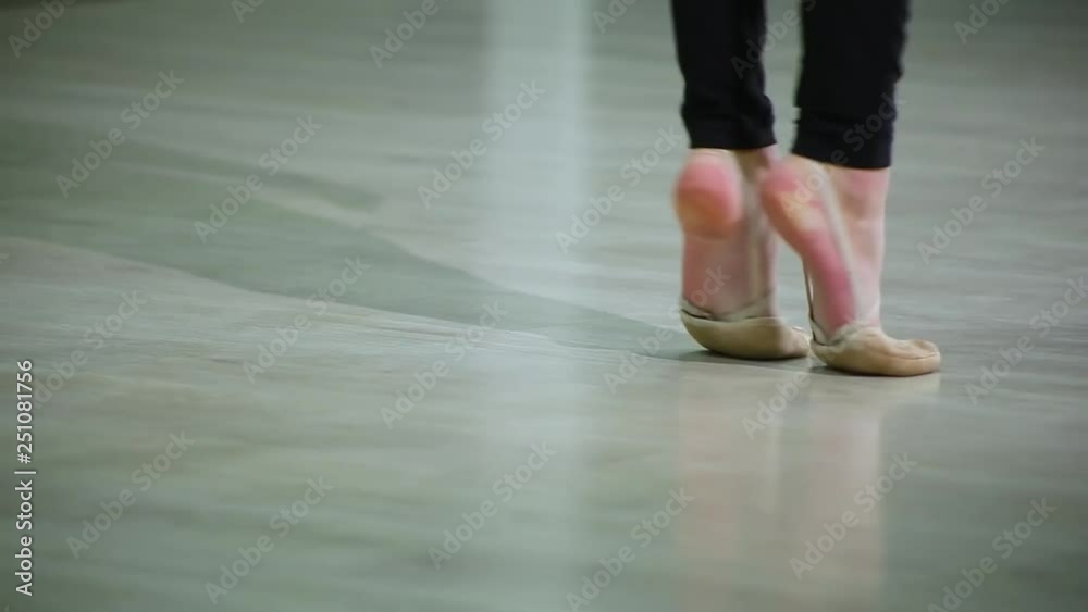 Close-up feet of ballerina in pointe performs dance ballet elements and different exercises in sport gym for rhythmic gymnastics Close-up feet of ballerina in pointe performs dance ballet elements and different exercises in sport gym for rhythmic gymnastics