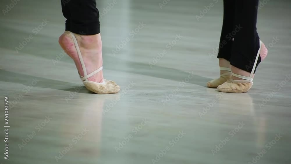 Close-up feet of ballerinas in pointe perform dance ballet elements and different exercises in sport gym for rhythmic gymnastics Close-up feet of ballerinas in pointe perform dance ballet elements and different exercises in sport gym for rhythmic gymnastics