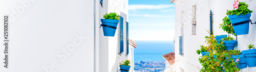 Cuadro en lienzo Panorama of Mijas with flower pots in facades