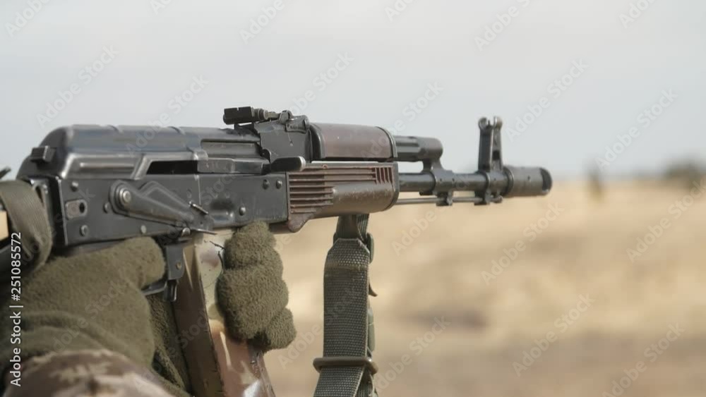 Hands shooting from AK 74 in a khaki uniform in a range in slow motion Hands shooting from AK 74 in a khaki uniform in a range in slow motion