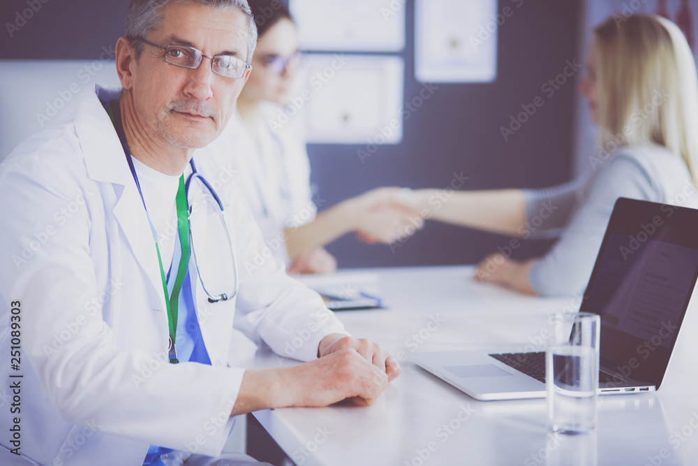 Doctor and patient discussing something while sitting at the table . Medicine and health care concept