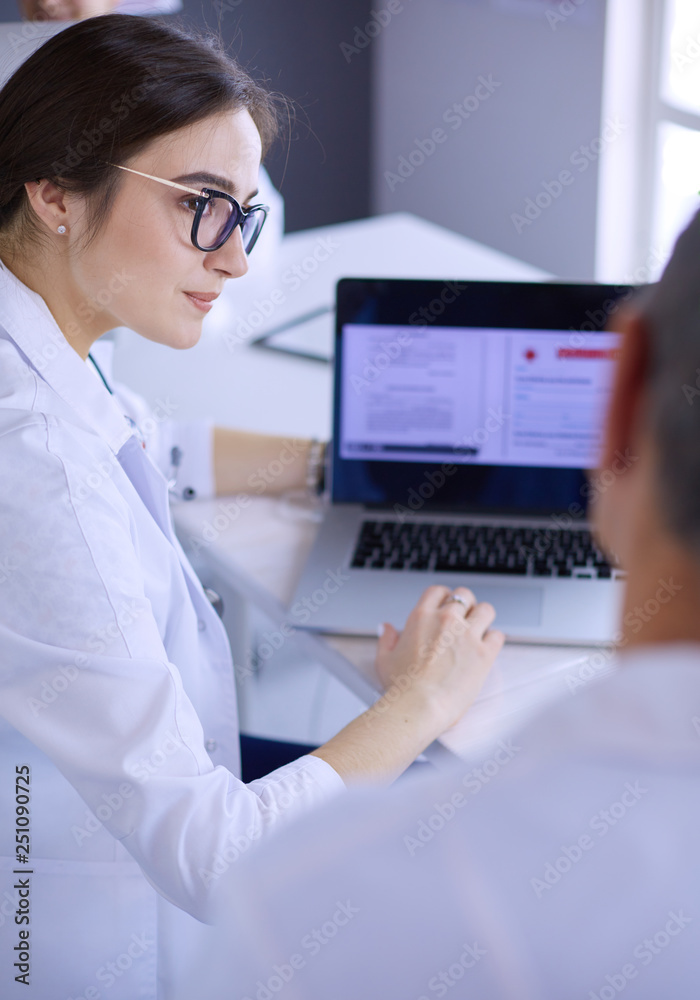 Serious medical team using a laptop in a bright office