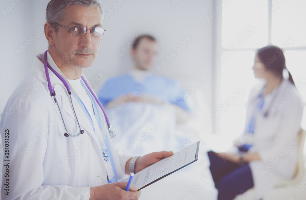 Doctor holding folder in front of a patient and a doctor Doctor holding folder in front of a patient and a doctor