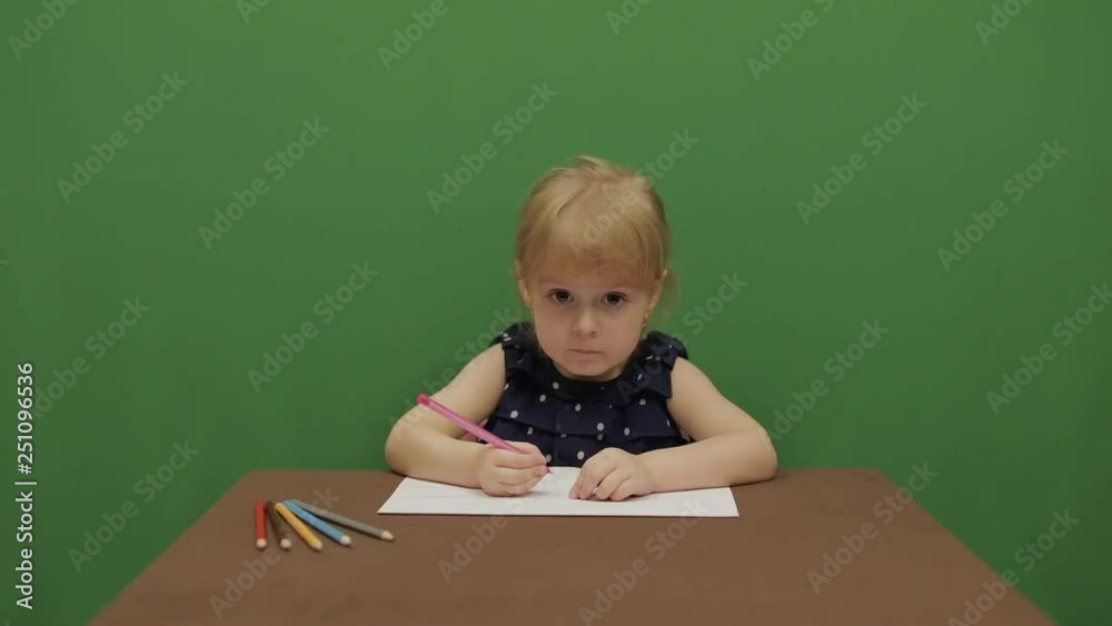 Girl drawing at the table. Education process. Raises her hand because she knows the answer to the question. Happy three years old girl. Cute girl smiling. Brown eyes. Green screen video. Chroma Key Girl drawing at the table. Education process. Raises her hand because she knows the answer to the question. Happy three years old girl. Cute girl smiling. Brown eyes. Green screen video. Chroma Key