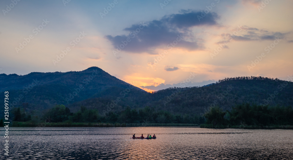 Group of tourists on a kayak paddle in dam river with mountain landscape view