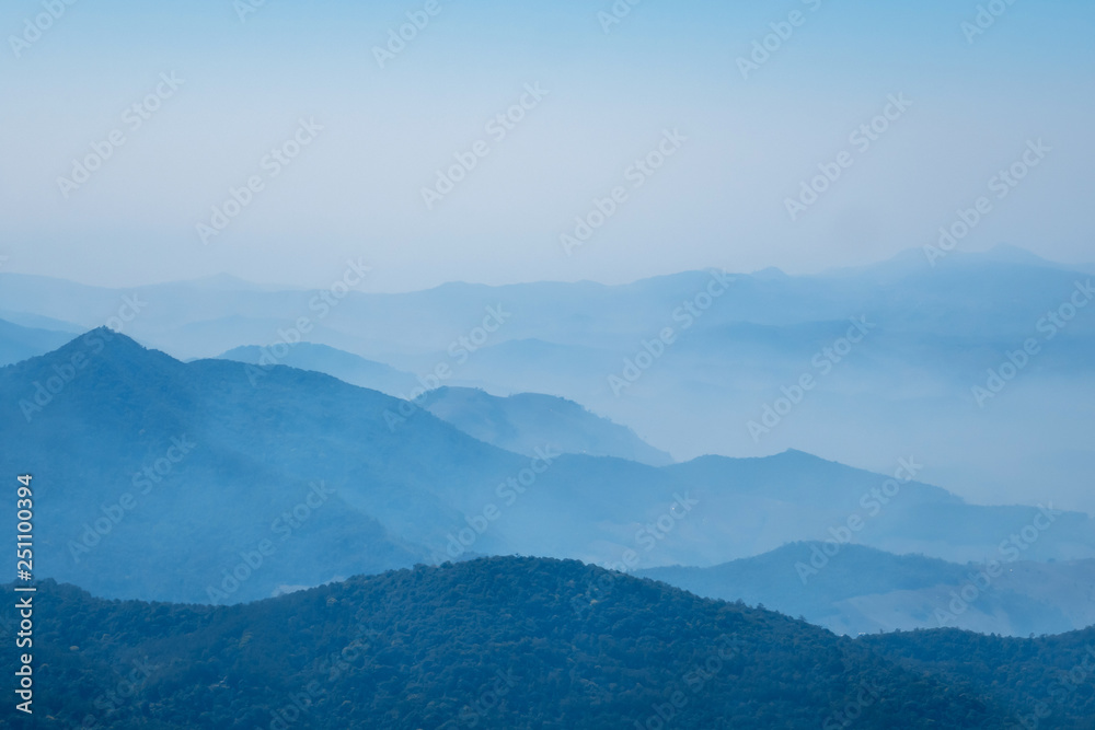 The mountains and forests with blue sky and white clouds at the peak of Inthanon national park (park name) in Chiang Mai province , Thailand in a foggy or misty day , real photo not graphic program.  