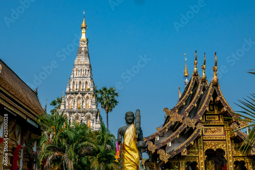 The monk who called Siwalee statue in the temple with chamber and pagoda background in the blue sky of sunny day. photo