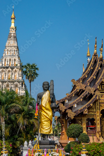 The monk who called Siwalee statue in the temple with chamber and pagoda background in the blue sky of sunny day. photo