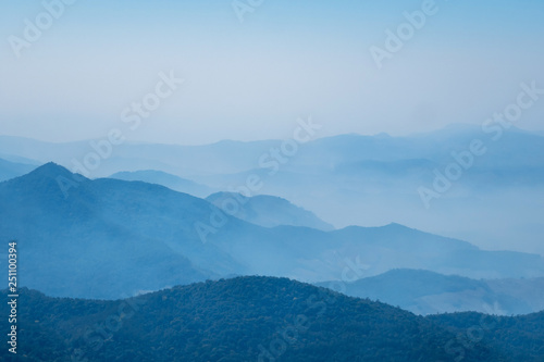 The mountains and forests with blue sky and white clouds at the peak of Inthanon national park (park name) in Chiang Mai province , Thailand in a foggy or misty day , real photo not graphic program. 