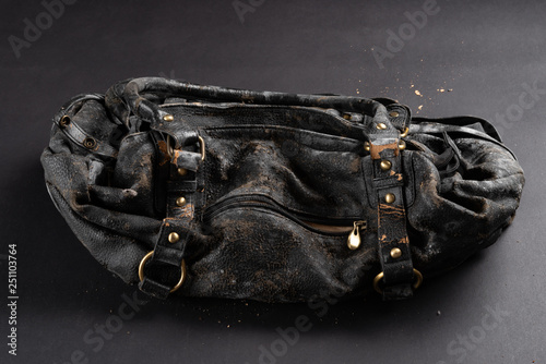 moldy leather bag on dark background photo