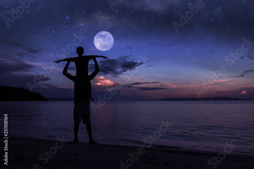 Silhouette father and daughter on the beach with million stars galaxy
