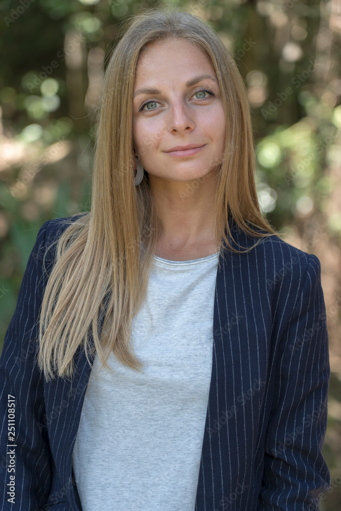 Beautiful caucasian blonde girl in a business suit in nature background. A portrait of a young business woman in tropical garden, Thailand Beautiful caucasian blonde girl in a business suit in nature background. A portrait of a young business woman in tropical garden, Thailand