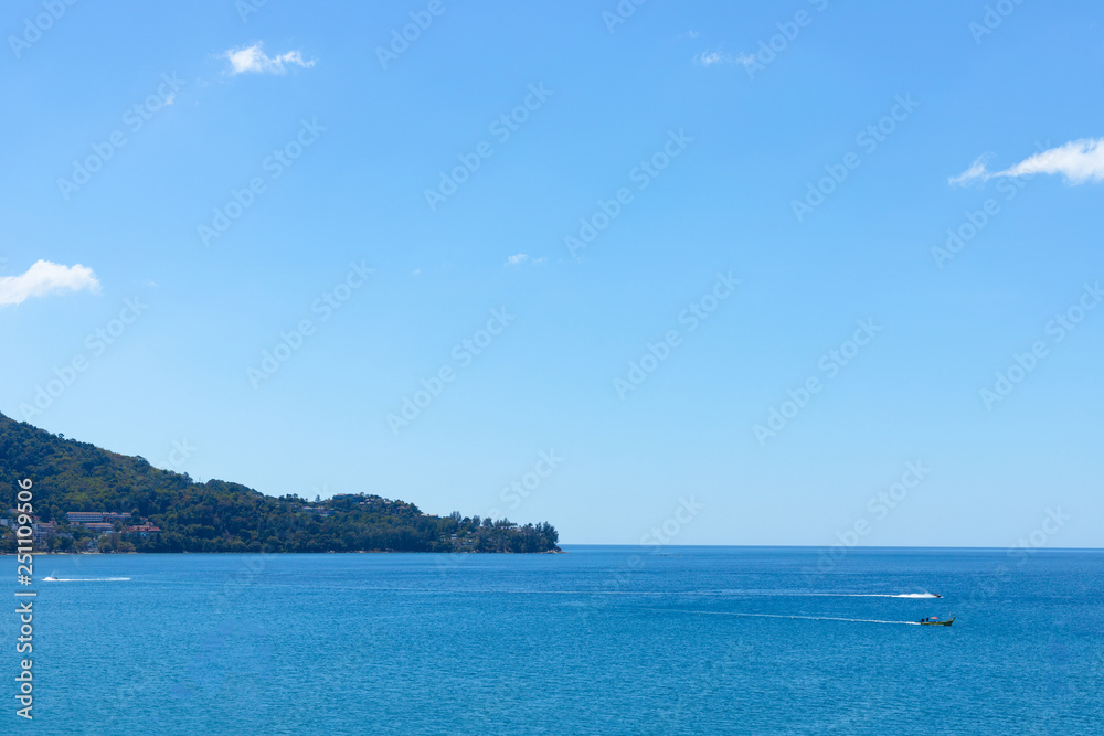 Blue sky and ocean in cleary day, have Phuket island and long tail boat drive pass through