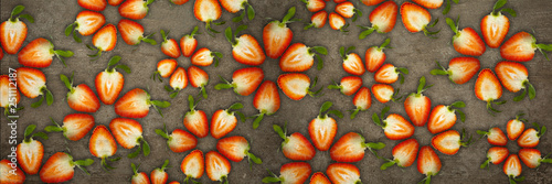 Creative flowers made of strawberries cut from below lit on a stone background Food concept Banner