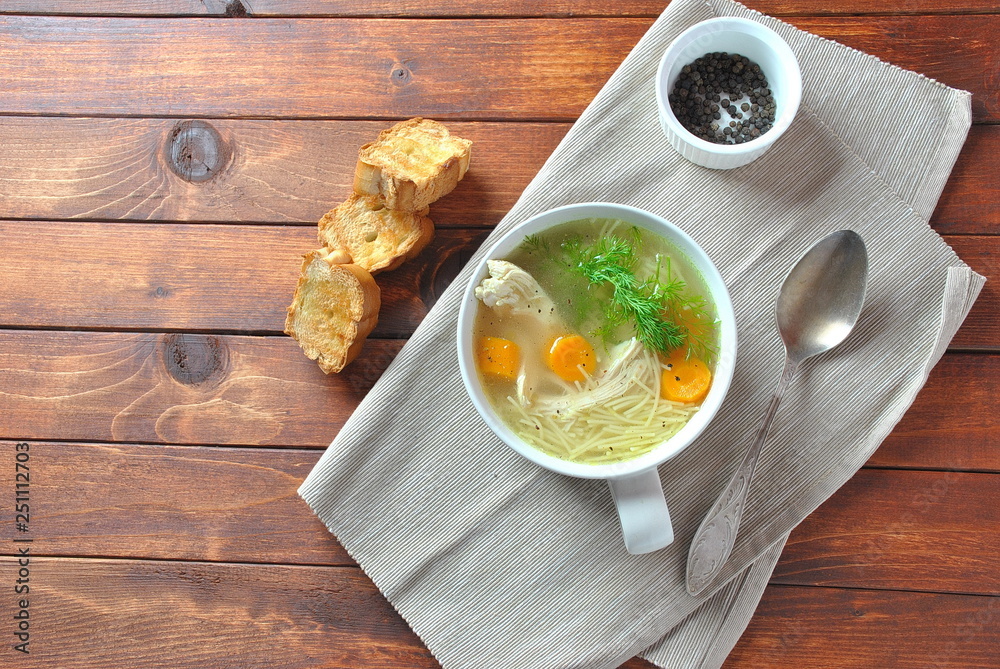 Chicken soup with noodles and vegetables in bowl on wooden background homemade healthy meal Chicken soup with noodles and vegetables in bowl on wooden background homemade healthy meal