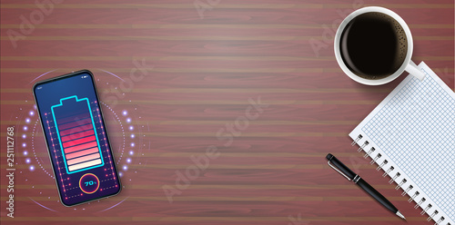 Charge your phone wirelessly. Charging the phone is built into the desktop. The future of charging gadgets. Desktop coffee Cup notebook pen charging phone, business background.
