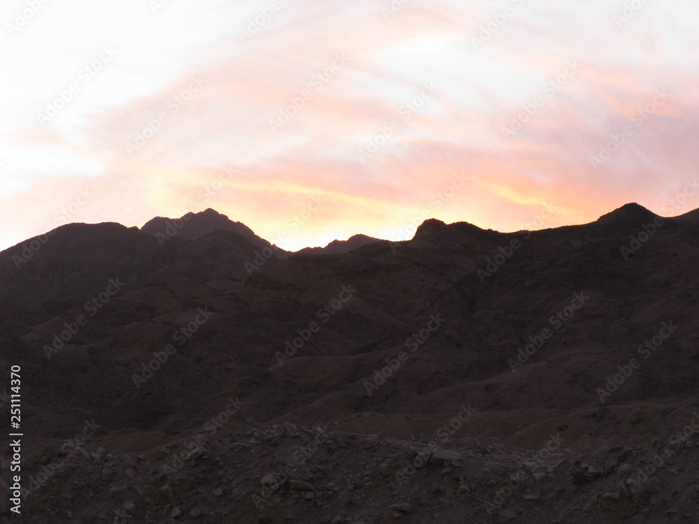 Desierto de Dahab, montañas de Egipto en la noche fotos contra del sol, nubes rosadas