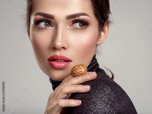 Beautiful young fashion woman with living coral lipstick. Attractive white girl wears luxury jewelry.