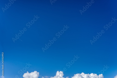 Fototapeta Naklejka Na Ścianę i Meble -  Fluffy white clouds against a bright, colorful blue sky