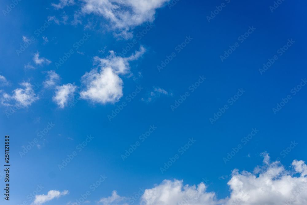 Fluffy white clouds against a bright, colorful blue sky Fluffy white clouds against a bright, colorful blue sky