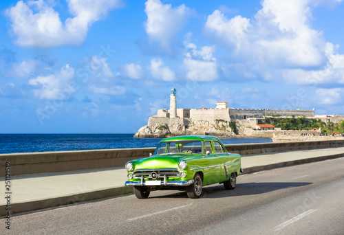 Amerikanischer grüner Cabriolet Oldtimer auf dem berühmten Malecon und im Hintergrund die Festung Castillo de los Tres Reyes del Morro in Havanna Kuba - Serie Kuba Reportage photo