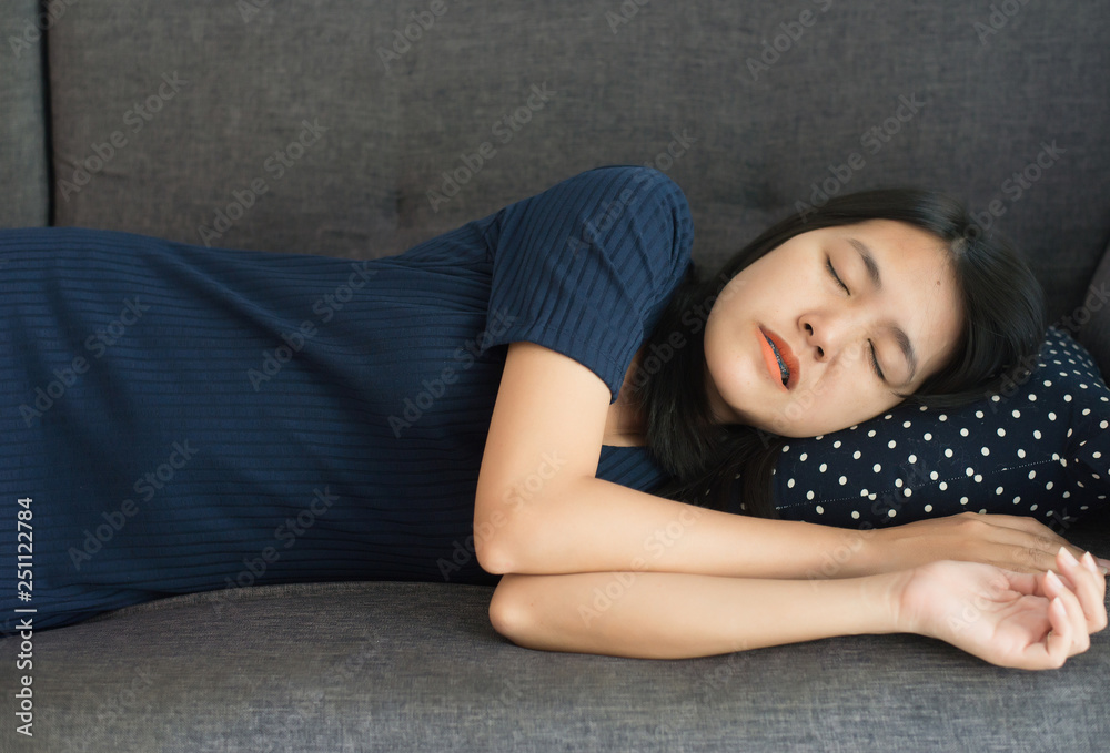 Women sleeping on sofa bed and grinding teeth,Female tiredness and stress at living room Women sleeping on sofa bed and grinding teeth,Female tiredness and stress at living room