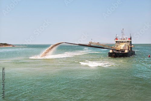 Dredge boat removing sand and silt from the bottom. Dredger ship works.Pumping sand.