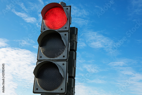Traffic red stoplight light on a background of blue sky