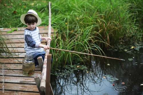 A child in a campaign catches fish in pond.
