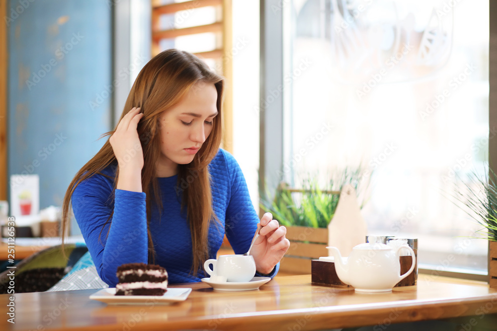 Young girl in cafe sits and drinks tea Young girl in cafe sits and drinks tea